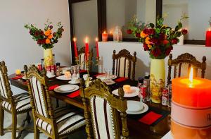 a dining room table with a candle and flowers at Casa Cojocaru in Cârcea