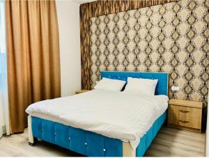 a bed with a blue headboard in a bedroom at Casa Cojocaru in Cârcea