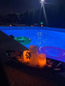 una bandeja de comida y velas en una mesa junto a la piscina en Casa Cojocaru, en Cîrcea