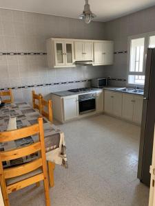 a kitchen with white cabinets and a table and chairs at Mittelmeer Villa 
