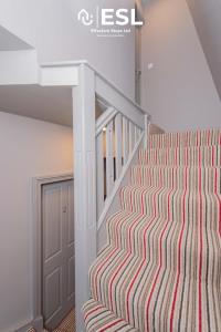 a staircase in a house with a striped carpet at Studio 1, First Floor Town Centre Apartment in Shrewsbury