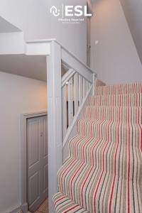 Una escalera en una casa con una alfombra a rayas. en Studio 1, First Floor Town Centre Apartment, en Shrewsbury