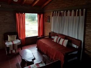 a bedroom with a bed and a window at Cabañas Mina Clavero La Amelia in Mina Clavero
