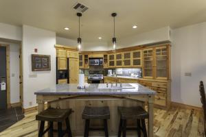 a kitchen with wooden cabinets and a large island with bar stools at 2 Bedroom Condo - The Lodges at Deer Valley condo in Park City