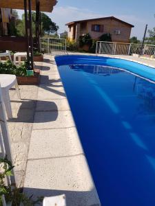 a blue swimming pool next to a house at Cabañas Mina Clavero La Amelia in Mina Clavero