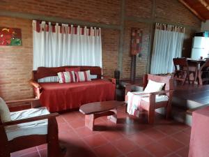 a living room with a couch and a table and chairs at Cabañas Mina Clavero La Amelia in Mina Clavero