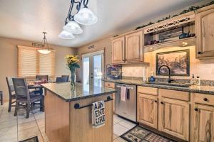 una cocina con armarios de madera y una isla de cocina con mesa en Family-Friendly Home with Hot Tub 1 Mi to Dtwn, en Estes Park