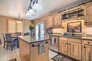 una cucina con armadi in legno e un'isola con cucina e tavolo di Family-Friendly Home with Hot Tub 1 Mi to Dtwn a Estes Park