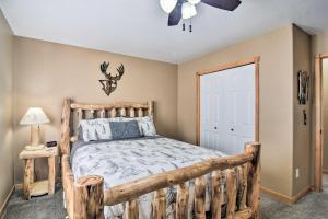 a bedroom with a wooden bed and a ceiling fan at Family-Friendly Home with Hot Tub 1 Mi to Dtwn in Estes Park