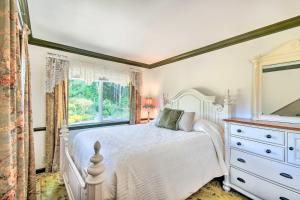 a bedroom with a white bed with a dresser and a window at Exceptional Chehalis Retreat with Scenic Views! in Chehalis