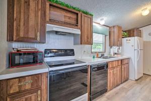 Una cocina con gabinetes de madera y un refrigerador blanco. en Peaceful Canal-Front Retreat with Boathouse!, en Leesburg