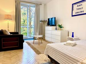 1 dormitorio con 1 cama, TV y sofá en Kalimera - Greek life apartment, en Varsovia