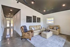 a living room with two couches and a table at Modern Norfork House with Patio on White River! in Norfork