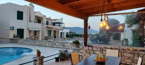 a patio with a table and chairs next to a pool at Villa Viva in Asprouliánoi