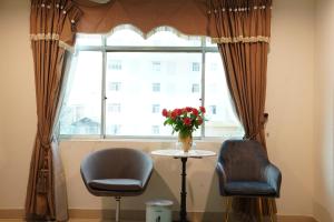 duas cadeiras e uma mesa em frente a uma janela em Trang An Hotel - 10 minutes Landmark 81 em Cidade de Ho Chi Minh