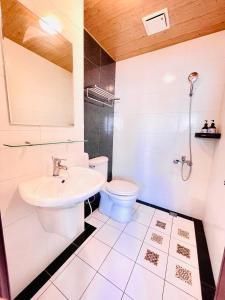 a white bathroom with a toilet and a sink at 安平六合居 六合館 in Tainan