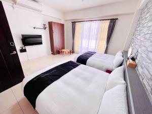 a hotel room with two beds and a tv at 安平六合居 六合館 in Tainan