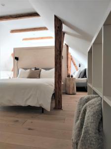 Schlafzimmer mit einem großen weißen Bett und Holzböden in der Unterkunft Chata Fraluq in Tatobity