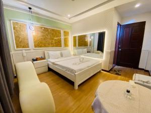 - une chambre avec un grand lit blanc et une chaise dans l'établissement Jewel Hotel, à Hô-Chi-Minh-Ville