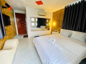 - un grand lit blanc avec une paire de ruban blanc dans l'établissement Jewel Hotel, à Hô-Chi-Minh-Ville