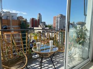 a balcony with chairs and a table with cups on it at Estilo Crespo in Buenos Aires
