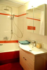 y baño con bañera, lavamanos y ducha. en Olive and Orange Apartment, en Mystras