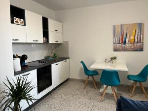 a kitchen with white cabinets and a table and chairs at Apartment Renata in Zadar