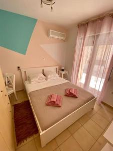 1 dormitorio con 1 cama con 2 toallas rosas en Villa Viva en Asprouliánoi