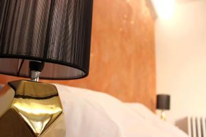 eine schwarze und goldene Lampe auf einem Bett in der Unterkunft Sublime appartement, chic et confortable. in Bourg-en-Bresse