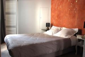 - une chambre avec un grand lit et un mur orange dans l'établissement Sublime appartement, chic et confortable., à Bourg-en-Bresse