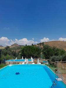 een groot blauw zwembad met een heuvel op de achtergrond bij Villa Parco Morello Primo Piano in Villarosa