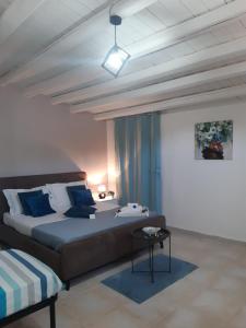 una camera da letto con un grande letto con cuscini blu di Ettore Casa Vacanze a Comiso