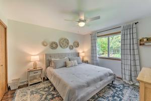 a bedroom with a bed with a ceiling fan and a window at Airy Cottage Close to Rock Lake with Fire Pit! in Lake Mills