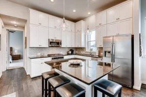 a kitchen with white cabinets and a stainless steel refrigerator at Fam Friendly 5 Bed Home Blocks To Pearl/Riverwalk! in San Antonio