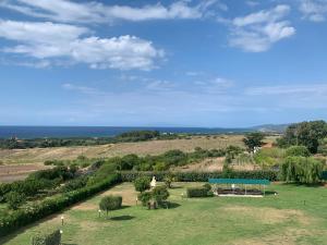 uma vista para um parque com uma mesa de piquenique e para o oceano em Residence Valledoria 2 int 8 em Valledoria