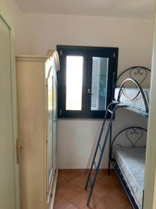 ein kleines Zimmer mit einem Etagenbett und einem Fenster in der Unterkunft Residence Valledoria 2 int 8 in Valledoria