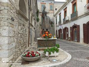 a statue in the middle of a street with flowers at La Casetta del Custode in Villa Santa Maria