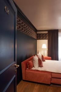 - une chambre avec un lit et un canapé rouge dans l'établissement Craves, à Bruxelles