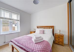 サンダースフットにあるThe Coach House Cambrian Quayのベッドルーム1室(ピンクの毛布と窓付)