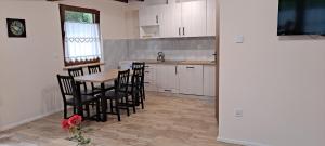 a kitchen with a wooden table and chairs in a room at Domek całoroczny Nad Stawem in Powidz