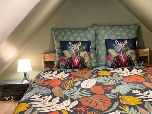 1 cama con edredón colorido y 2 almohadas en L’Amazonite - Etretat, en Étretat