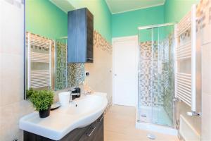 a bathroom with a sink and a glass shower at Hostly - Art & Color Rome Midtown - 3BR 2BA in Rome
