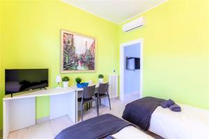a bedroom with a bed and a desk with a television at Hostly - Art & Color Rome Midtown - 3BR 2BA in Rome