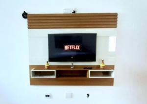 a flat screen tv sitting on top of a entertainment center at Lindo Ap Praia da Costa com Ar Condicionado in Vila Velha