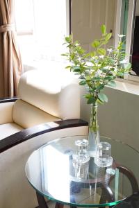 une table en verre avec un vase sur un canapé dans l'établissement Trang An Hotel - 5 minutes Landmark 81, à Hô-Chi-Minh-Ville