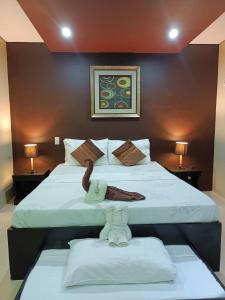 a bedroom with two beds and two tables with lamps at Casita Isla Beach Inn in Boracay