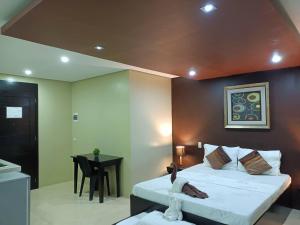a bedroom with a large bed and a table at Casita Isla Beach Inn in Boracay