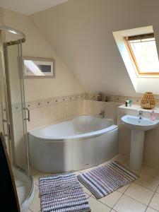 een badkamer met een groot bad en een wastafel bij Hen Pen in Montrose