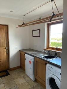 a kitchen with a sink and a washing machine at Hen Pen in Montrose +13 photos