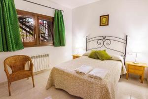 a bedroom with a bed with green curtains and a chair at Casa Xaupí Gran in Roní